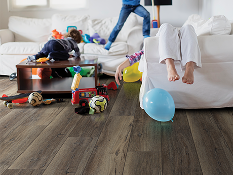 kids playing in room with wood-look laminate flooring from Carneys Carpet Gallery in Jeffersontown, KY